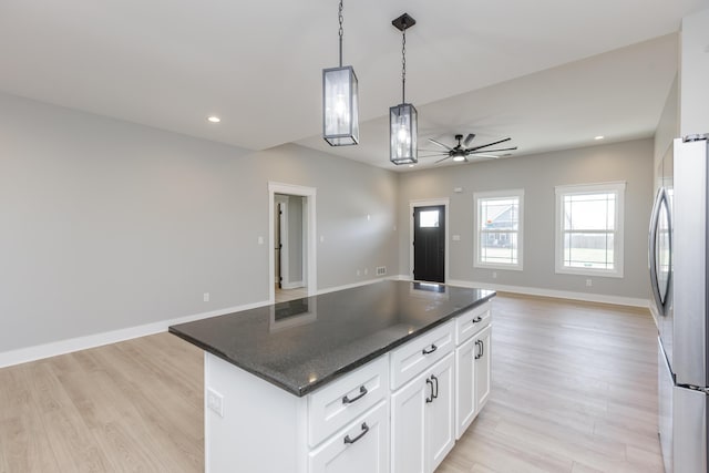 kitchen featuring open floor plan, light wood-style floors, freestanding refrigerator, and a ceiling fan