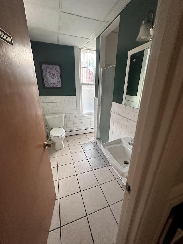 bathroom with a baseboard radiator, sink, tile walls, toilet, and tile patterned floors