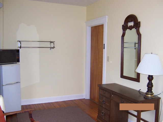 bedroom featuring white refrigerator and dark hardwood / wood-style flooring