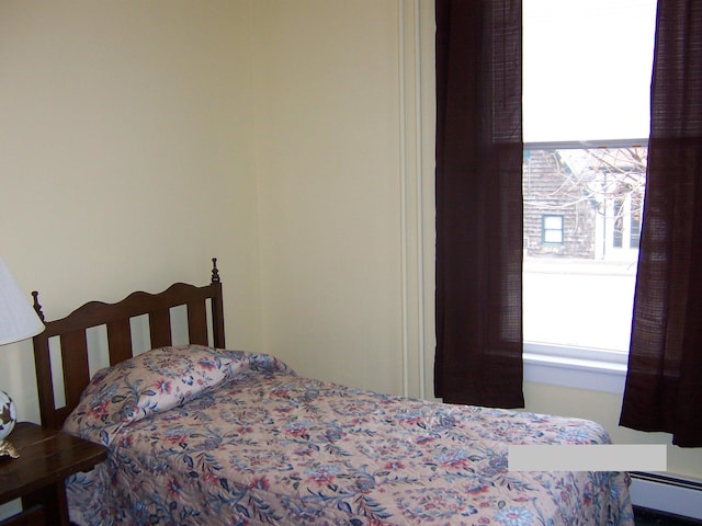 bedroom with multiple windows and baseboard heating