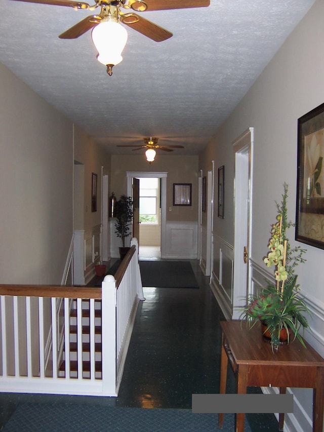 hall featuring a textured ceiling