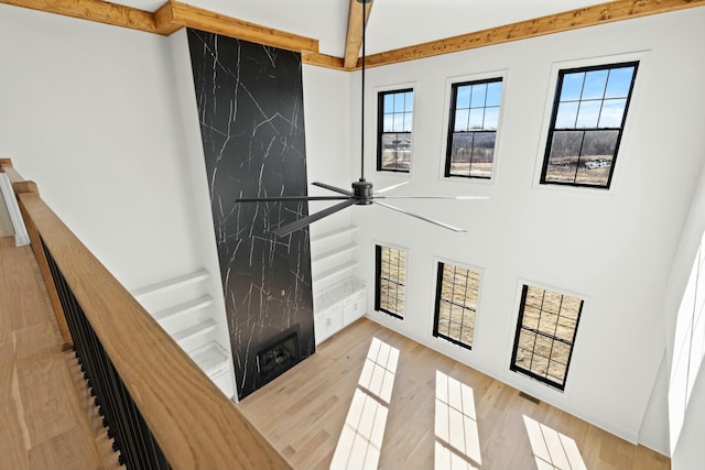 entryway with a towering ceiling, light hardwood / wood-style floors, and ceiling fan