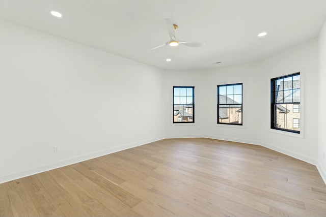 empty room with ceiling fan and light hardwood / wood-style flooring