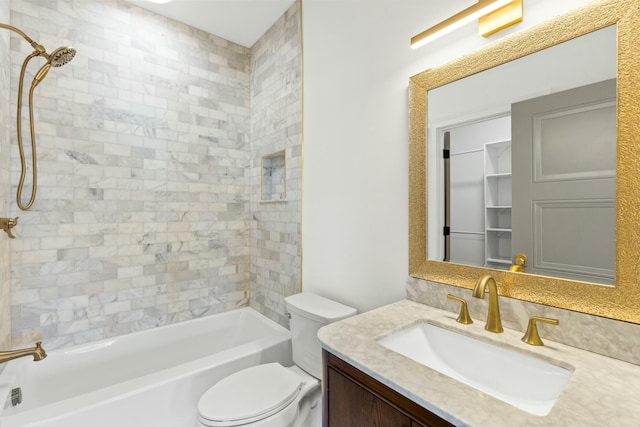 full bathroom featuring tiled shower / bath, vanity, and toilet