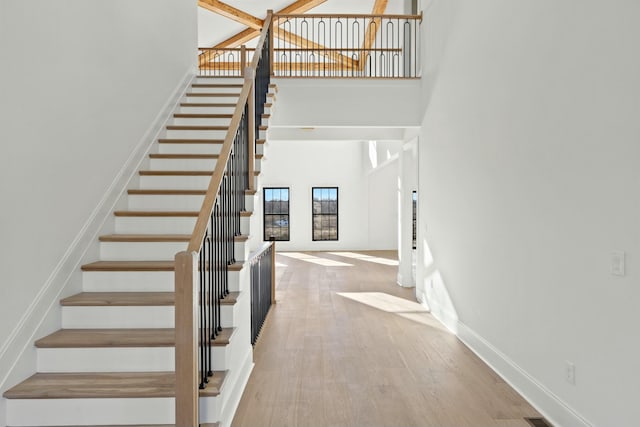 staircase featuring hardwood / wood-style floors and a high ceiling