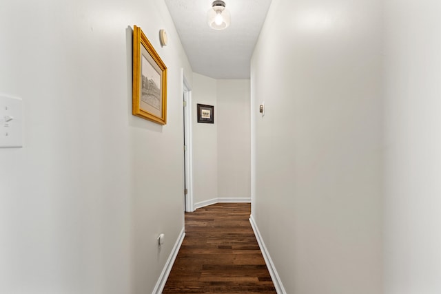 hallway with dark hardwood / wood-style floors and a textured ceiling