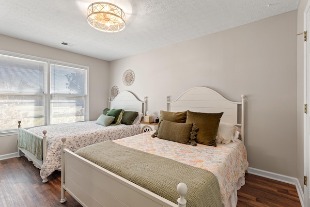 bedroom with dark wood-type flooring and a textured ceiling