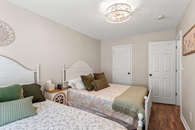 bedroom featuring dark wood-type flooring and a textured ceiling