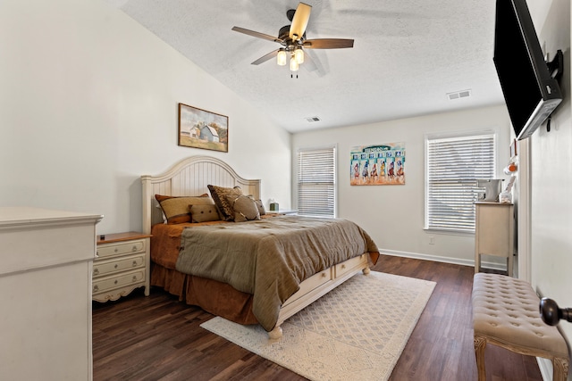 bedroom with ceiling fan, lofted ceiling, dark hardwood / wood-style floors, and a textured ceiling