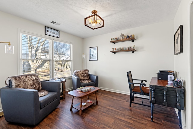 home office with dark wood-type flooring and a textured ceiling