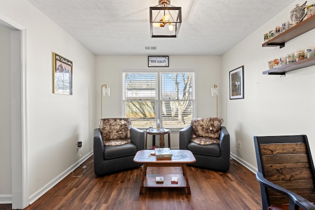 living area featuring dark hardwood / wood-style floors and a textured ceiling