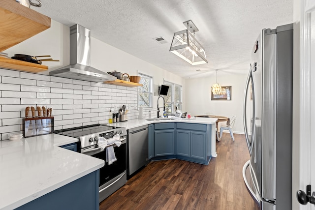 kitchen with island range hood, sink, kitchen peninsula, stainless steel appliances, and blue cabinetry