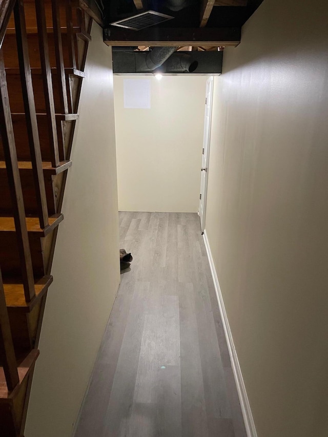 hallway with light wood-type flooring and baseboards