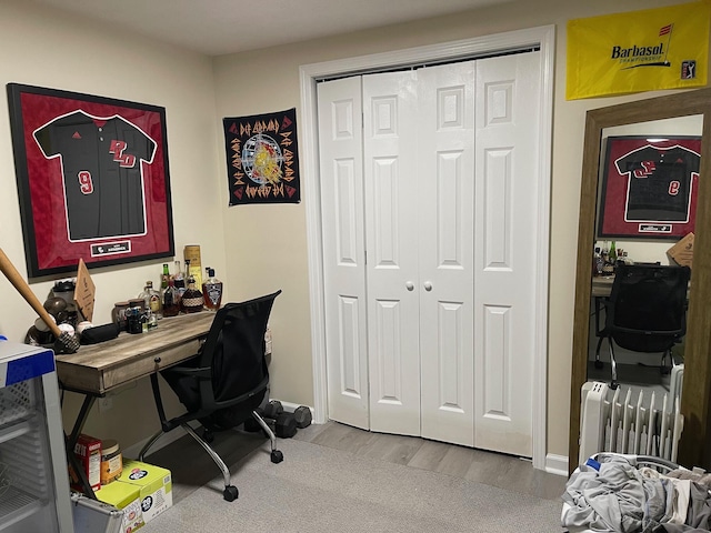 office area featuring light wood-style flooring and radiator heating unit