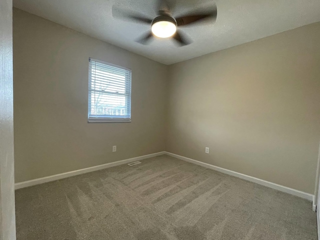 carpeted spare room with ceiling fan