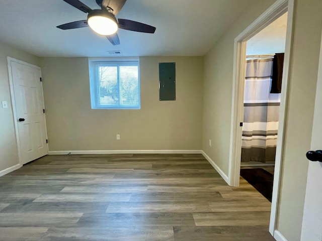 unfurnished bedroom with connected bathroom, electric panel, ceiling fan, and light hardwood / wood-style flooring