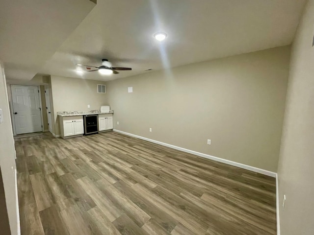 unfurnished living room featuring light hardwood / wood-style floors, beverage cooler, and ceiling fan