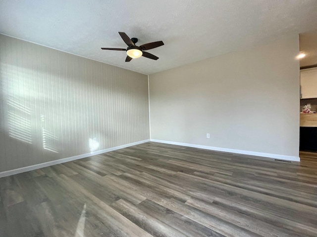 spare room featuring ceiling fan and dark hardwood / wood-style floors