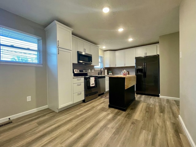 kitchen with white cabinetry, decorative backsplash, stainless steel appliances, and a kitchen island