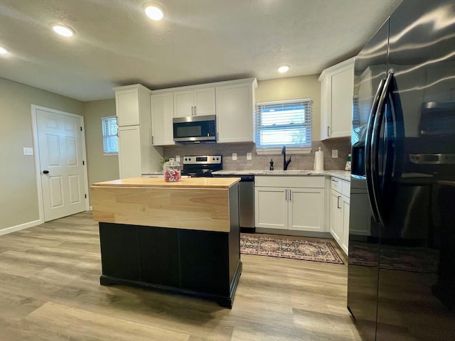 kitchen with sink, white cabinets, and appliances with stainless steel finishes