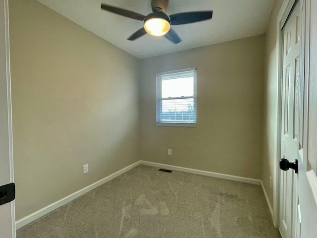 spare room featuring ceiling fan and light colored carpet