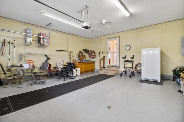 garage with white refrigerator, ceiling fan, a garage door opener, and electric panel