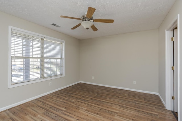 unfurnished room with ceiling fan, dark hardwood / wood-style floors, and a textured ceiling