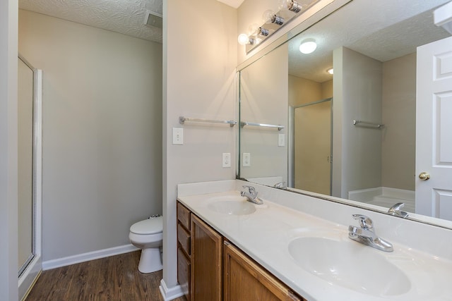 full bathroom with shower with separate bathtub, wood-type flooring, vanity, toilet, and a textured ceiling