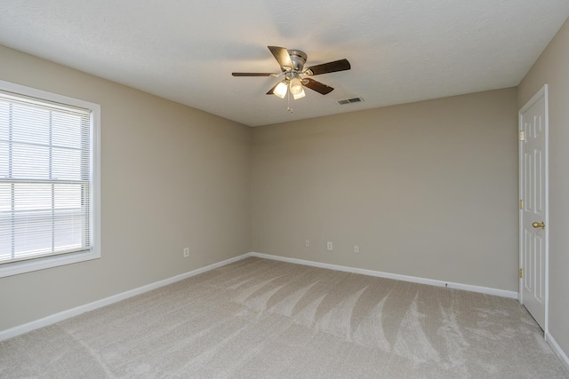 carpeted spare room with ceiling fan and a textured ceiling