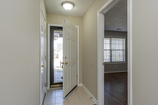 foyer entrance with light tile patterned floors and a textured ceiling