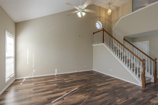 unfurnished living room with ceiling fan, dark hardwood / wood-style floors, and high vaulted ceiling