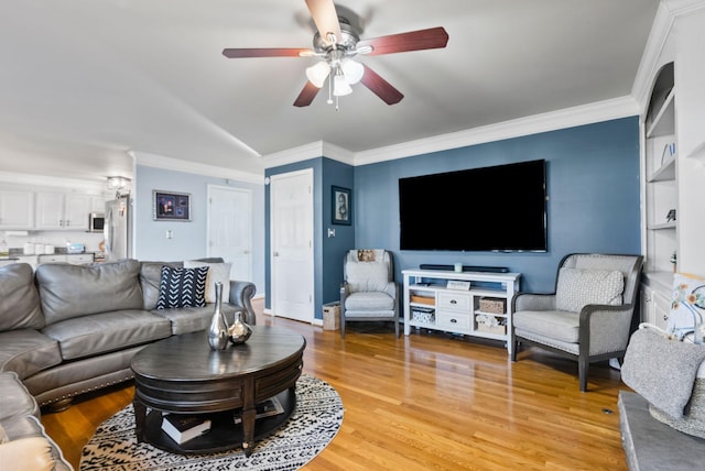 living room featuring crown molding, ceiling fan, and light wood-type flooring