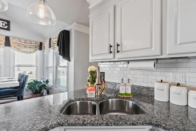 kitchen with white cabinetry, tasteful backsplash, lofted ceiling, and dark stone counters