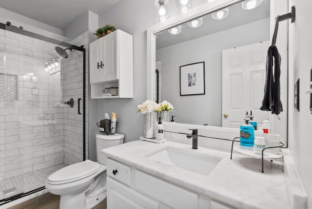 bathroom featuring vanity, hardwood / wood-style floors, toilet, and walk in shower