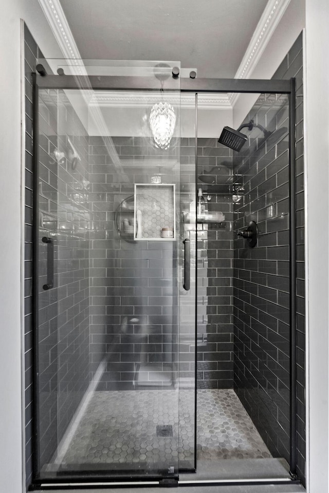 bathroom with crown molding and a shower with shower door