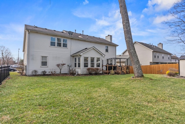 back of property with a pergola, a yard, and a deck