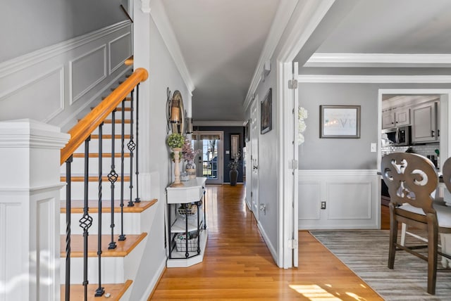 foyer with ornamental molding and light hardwood / wood-style flooring