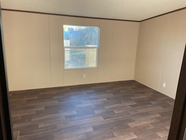 unfurnished room with crown molding, dark hardwood / wood-style floors, and a textured ceiling