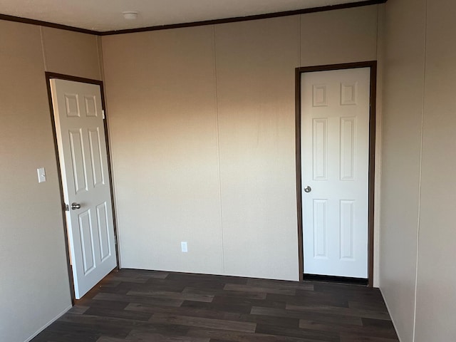 spare room featuring crown molding and dark hardwood / wood-style floors