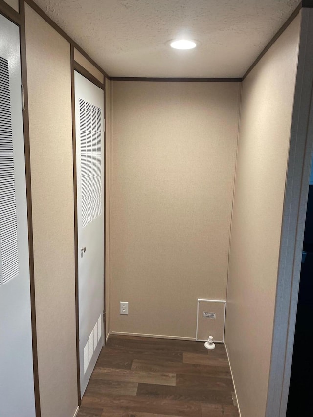 clothes washing area with dark hardwood / wood-style floors and a textured ceiling