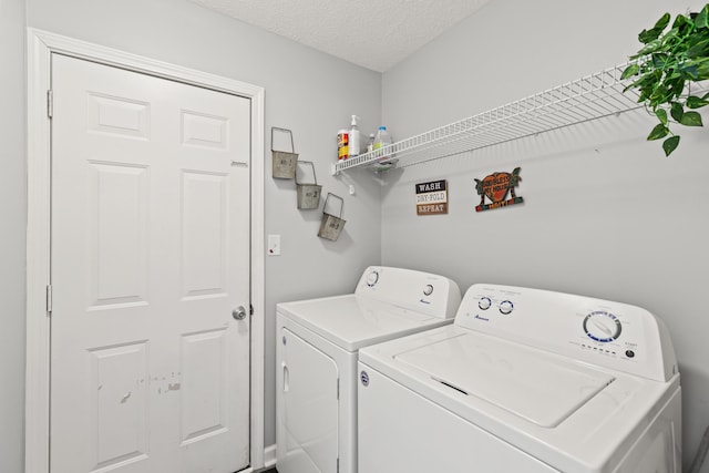 laundry room featuring a textured ceiling and washing machine and clothes dryer