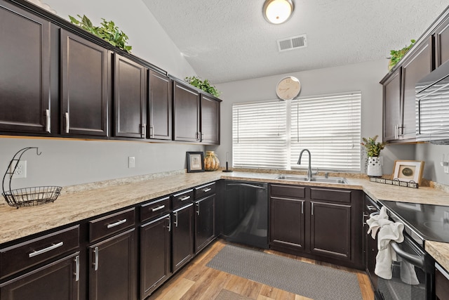 kitchen with sink, vaulted ceiling, a textured ceiling, light hardwood / wood-style flooring, and black appliances