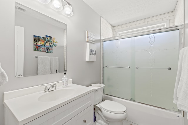 full bathroom featuring bath / shower combo with glass door, vanity, toilet, and a textured ceiling