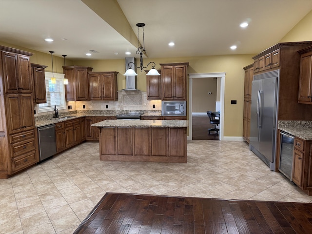 kitchen featuring built in appliances, decorative light fixtures, light stone countertops, and a kitchen island