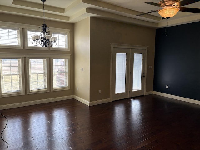 unfurnished room with dark hardwood / wood-style flooring, a raised ceiling, ceiling fan with notable chandelier, and a high ceiling