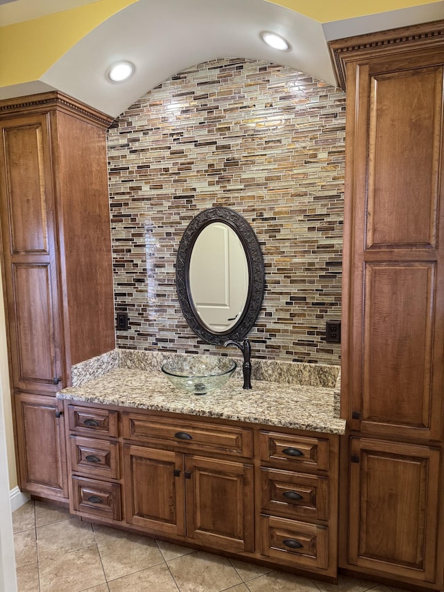 bathroom with vanity, tile patterned flooring, and backsplash