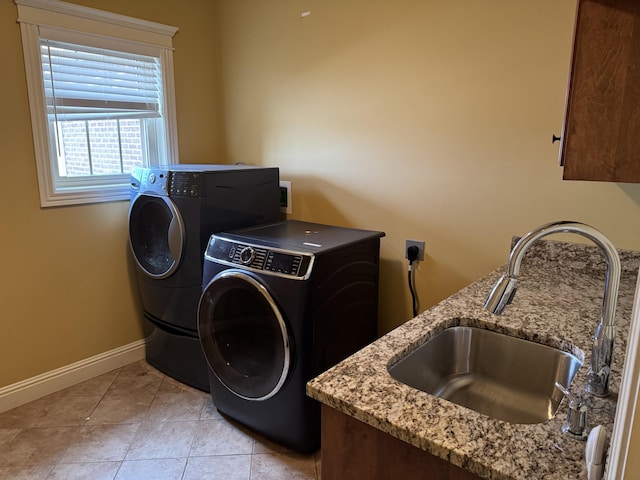 laundry area featuring cabinets, washing machine and dryer, sink, and light tile patterned floors