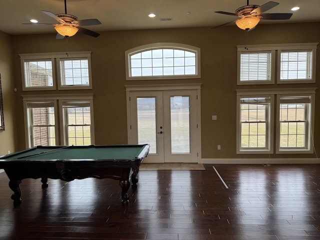 game room with a high ceiling, ceiling fan, dark hardwood / wood-style flooring, and french doors