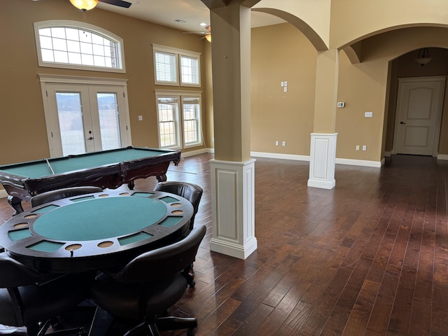 recreation room with french doors, ornate columns, dark hardwood / wood-style flooring, a towering ceiling, and ceiling fan