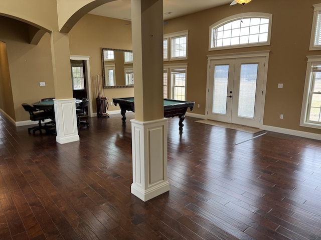 foyer entrance featuring french doors, a towering ceiling, plenty of natural light, and dark wood-type flooring